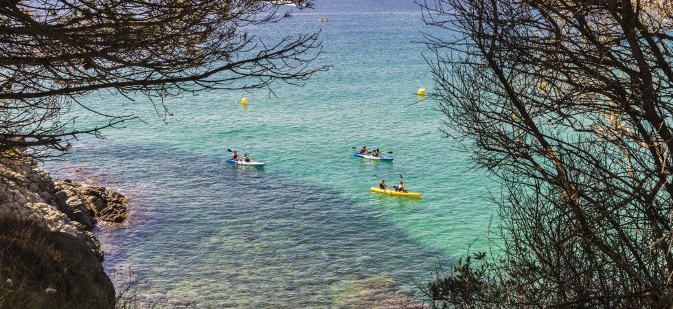 La Fosca beach with people practicing kayaking in Costa Brava, Girona, Catalonia, Spain