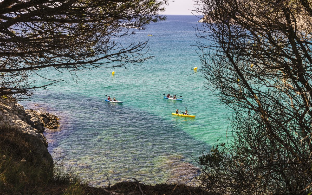 La Fosca beach with people practicing kayaking in Costa Brava, Girona, Catalonia, Spain